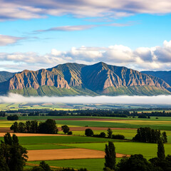 Majestic Mountain Range Overlooking Green Fields and Blue Skies