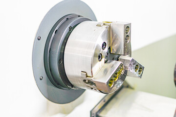 Close-up view of a metallic, cylindrical mechanical part with multiple holes and boltsrivets Monochromatic color scheme gray, silver Well-lit from above, casts shadows Potential educational use