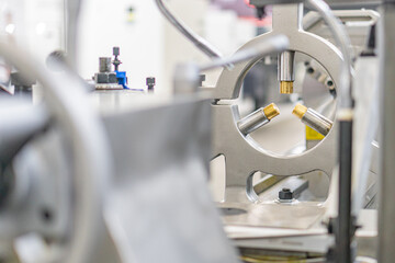 Close-up view of a manufacturing process in an industrial setting, featuring a large mechanical...