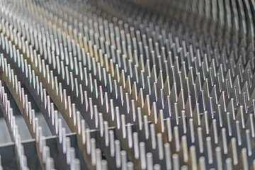 Fototapeta premium Close-up view of a metallic, grid-like mechanical structure in an industrial setting Precision engineered, reflective components with symmetrical, finned segments fit snugly together Subtle reflect