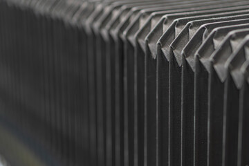 Close-up of grey, metallic structure with angular protrusions, uniform texture, and subdued lighting