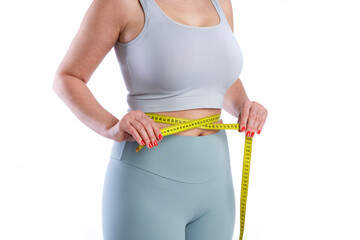 Young woman measuring her waistline