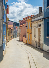 View of a winding road in Carino, Galicia, Espana, on a sunny day. Beutiful colorful houses