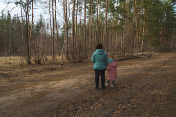 Fototapeta premium Grandmother and granddaughter walking in the forest
