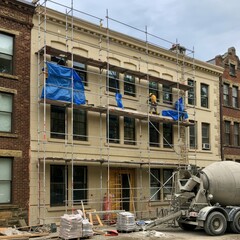 Naklejka premium Construction Workers Repairing Building Facade with Scaffolding
