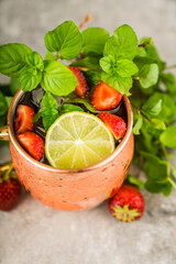 Refreshing Moscow mule cocktail with strawberries on the rustic background. Selective focus.