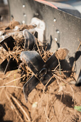 Detailed CloseUp View of an Agricultural Tiller Featuring Soil and Roots for Farming