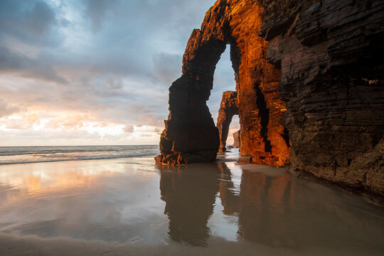 Reflections at sunset at praia das catedrais, galicia, espana