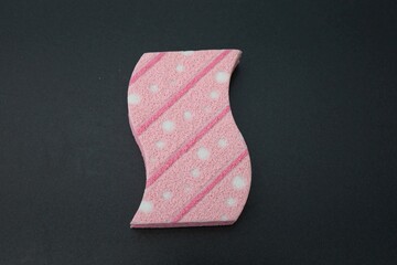 Pink sponge on a dark background.