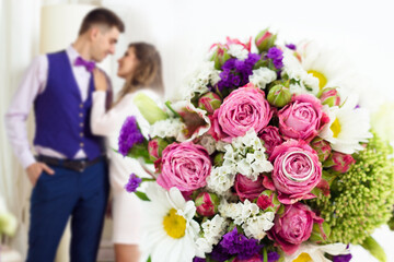 Couple in love. Wedding day. Close up of a bouquet of flowers with an engagement ring. Happy couple...