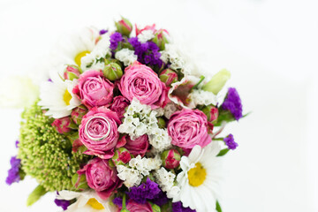 Wedding day. Closeup bouquet of flowers and one ring on the day of the engagement.