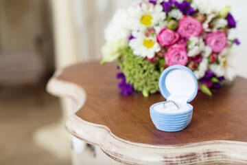 Wedding day. Closeup gift box with ring and bouquet of flowers on the day of the engagement.