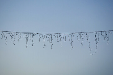 horizontal led light chain of winter snow hanging is the blue sky switched off during daylight