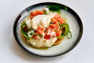 A Delicious Plate Featuring Poached Egg, Fresh Tomato, and Zucchini Ribbons Drizzled with Creamy Sauce for a Gourmet Culinary Experience