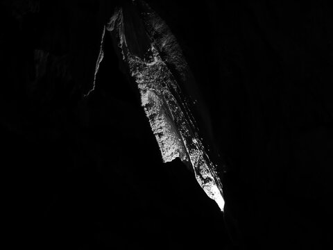 black and white image of a natural stone formation in a cave looking like a sharp meteorid