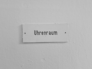 Label of a door with german word "Uhrenraum" (timing room) written on white paint