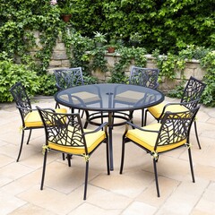 Obraz premium Outdoor dining set with six chairs and a round table on a patio.