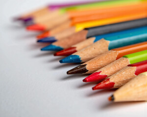 photograph of sharpened multicolored colored pencil tips arranged tightly with vibrant pigments and soft lighting, showcasing texture and symmetry for creative and education visuals