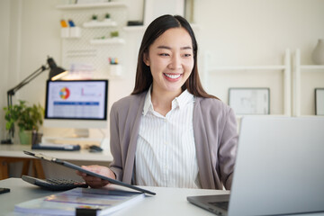Confident female accountant checking documents with charts and graphs during work.