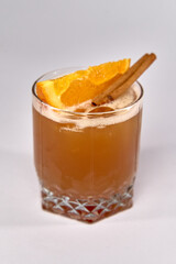 Refreshing Cocktail with Citrus and Cinnamon Garnish in a Clear Glass, Perfect for Celebrations and Relaxation Amidst Friends and Family Gatherings