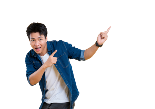 A young man is pointing his fingers upward with surprise on png background. He is wearing a denim shirt and a white t-shirt - Powered by Adobe