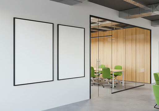 Modern office interior featuring blank framed posters, a glass-walled meeting room with green chairs. - Powered by Adobe