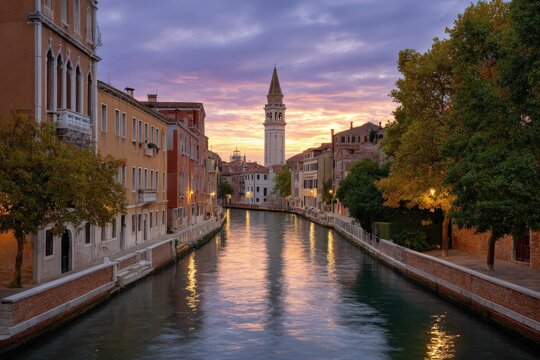 Venice canal scene tower reflects in water under a sunset sky between buildings and trees