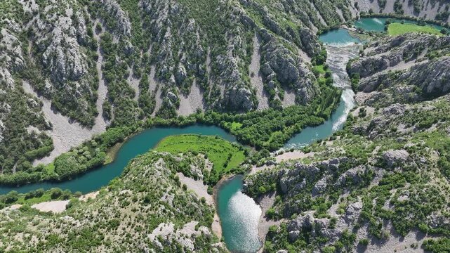 Aerial view where rivers Krnjeza and Krupa merge. Aerial shots of winding Zrmanja river cutting through deep canyon, lush spring colors and remote paths