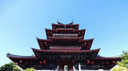 Fototapeta premium Traditional Asian Pagoda Tower Against a Clear Blue Sky