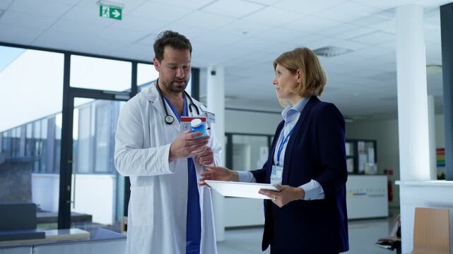 Female medical sales representative presenting medication to doctor