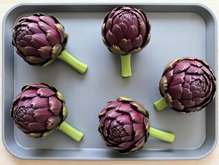 Fototapeta premium Five Purple Artichokes on a Gray Baking Sheet