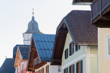 Alpine town with historic buildings - facades of traditional houses with different types of roofs and the steeple of a church create the atmosphere of an old European settlement Austria, St. Wolgang