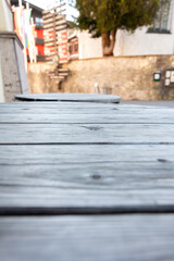 Aged wood texture in street interior - close-up of grey wooden boards on a table with blurred background, copy space,