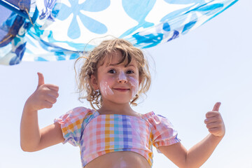 The child has sunscreen on his face. Selective focus.