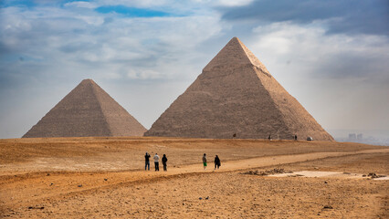 Tourists seen taking photos of the Great Pyramids of Giza from the desert in Egypt - an iconic...