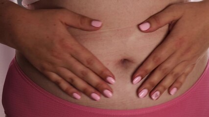 female hands heart shape belly closeup pink underwear bare skin manicure concept of women health body positivity self love