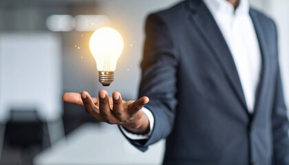 3D scene with a lightbulb-shaped idea icon floating above the hand of a blurred man in a suit