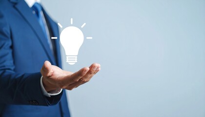 3D scene with a lightbulb-shaped idea icon floating above the hand of a blurred man in a suit