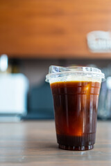 Refreshing americano coffee glass with ice on a wooden table