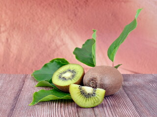 Kiwi fruits with leaveson wooden table. Copy space.