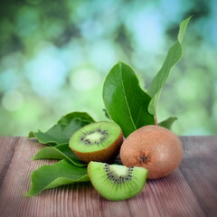 Kiwi fruits with leaveson wooden table. Copy space.