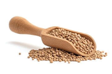 A wooden scoop full of mung beans resting beside a small pile of beans isolated on white background