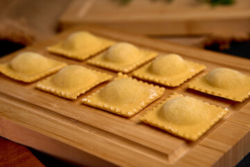 Delicious Homemade Ravioli Gathered on a Wooden Surface, Showcasing a Traditional Italian Pasta Dish Awaiting Cooking and Serving to Delight Food Lovers