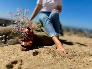 on the beach girl in a white t-shirt and jeans with flowers