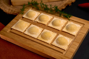 Handmade Ravioli Prepared with Care, Perfectly Placed on a Wooden Board, Showcasing Each Delicious Pocket of Pasta Filled with Flavor.