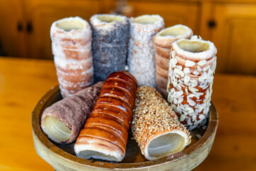 A wooden tray with a variety of doughnuts and pastries