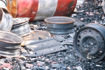 A pile of rusted and burnt car parts, including a tire