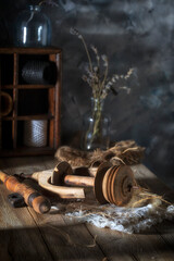 Details of an old broken spinning wheel on a rustic table