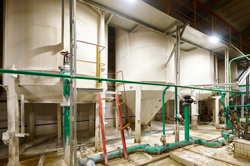 Machinery operates in a modern industrial facility during the day, showcasing equipment and storage...