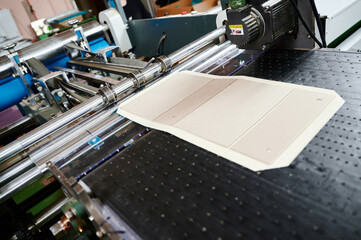 Efficient cardboard box flap folding machine in action at a packaging facility